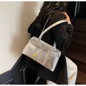 Detail of silver metallic shoulder bag with double straps and yellow key charm detail