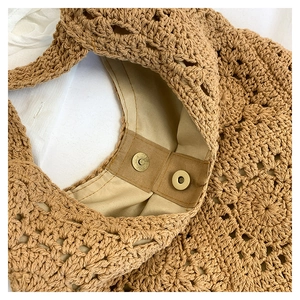 Detailed macro view of the cotton knit bag showing fabric lining and magnetic clasp