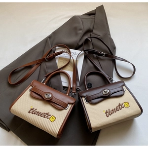 Detail of vintage patchwork handbag with 'timetc' embroidery and metal twist lock closure