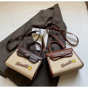 Close-up of retro canvas and leather patchwork handbags with detailed logo embroidery