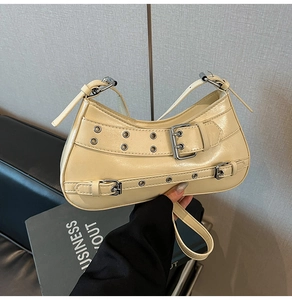Détail du sac à main en cuir PU crème avec œillets argentés et boucles métalliques