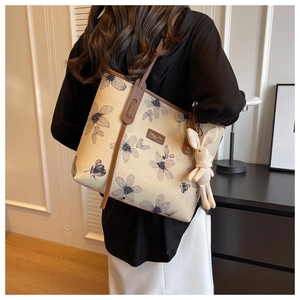 Détail du grand sac cabas en toile fleurie avec anses cuir et pendentif lapin