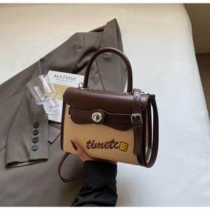 Detail of contrast stitch straw handbag with leather handle and timetc embroidery detail