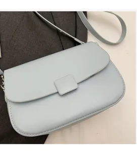 Close-up of soft light blue PU leather cross-body bag with smooth texture and buckle detail
