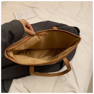 Top view of spacious straw tote interior with smooth zipper closure and brown leather straps