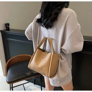 Sac seau marron en cuir grainé avec bandoulière réglable et détails de texture