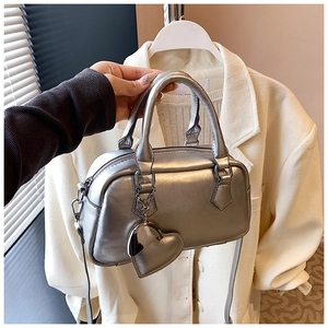 Detail of silver metallic bowling bag with heart charm and matching top handles