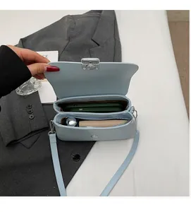 Detail view of the spacious inner compartments and metal clasp of the light blue leather bag