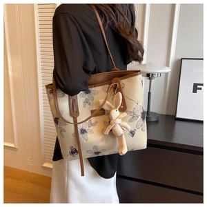 Détail du sac cabas vintage en toile fleurie avec pendentif lapin en tricot mignon
