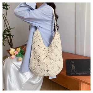 Close-up of handmade crochet flower patterns on cream cotton woven tote bag