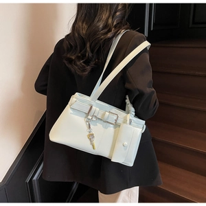 Detail view of light green shoulder bag with buckle strap and small hanging coin pouch
