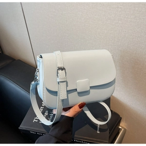 Detail view of the light blue shoulder bag showing precision stitching and silver buckle