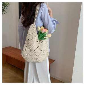 Detailed close-up of a large beige hand-woven floral hollow crochet tote bag