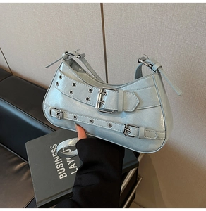 Détail du sac baguette bleu clair brillant avec œillets et boucles métalliques