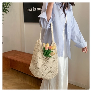 Close-up of beige crochet tote bag with hollow flower patterns in a boho style