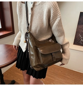 Vue détaillée du sac bandoulière en cuir brillant olive foncé avec poche à rabat