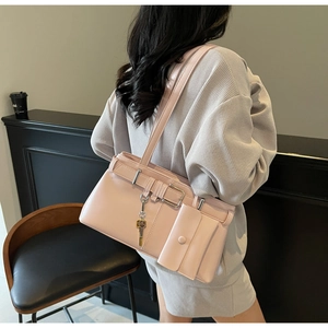 Detail of light pink patent leather shoulder bag with belt accent and small pouch