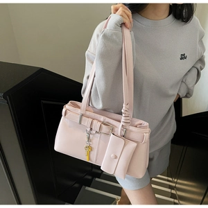 Pink faux leather shoulder bag with decorative buckle and mini pouch hanging detail