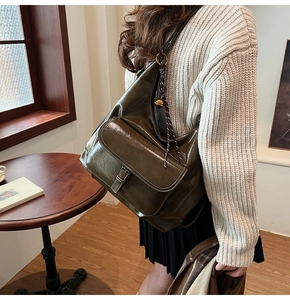 Sac à épaule en cuir vert olive rétro de grande capacité porté par un mannequin