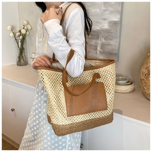 Detail of woven straw tote bag featuring a brown leather pocket and slim shoulder straps