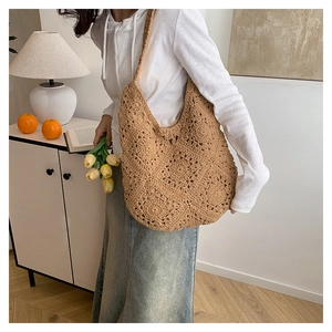 Detail of handmade khaki crochet tote bag with hollow flower pattern and large capacity