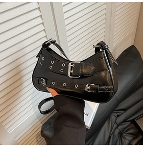 Détail du sac à bandoulière punk Y2K noir montrant les œillets argentés et boucles