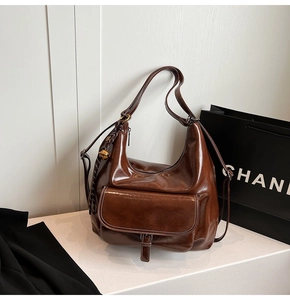 Détail du sac hobo vintage marron foncé avec poche à rabat et texture similicuir