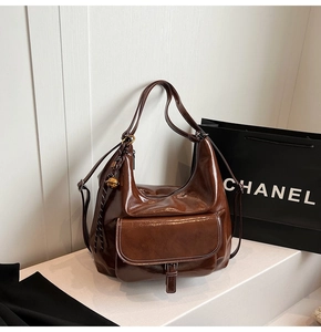 Détail du sac hobo vintage en cuir ciré marron foncé avec surpiqûres contrastées et poche