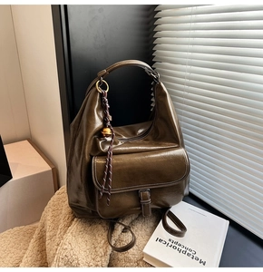Détail du sac à dos vintage vert olive foncé avec boucle métallique et texture plissée