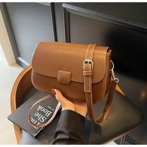 Detail view of the caramel brown leather crossbody bag with silver hardware and vintage texture