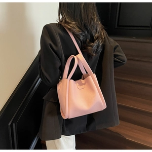 Détail du sac seau rose en cuir litchi montrant la texture et le texte imprimé