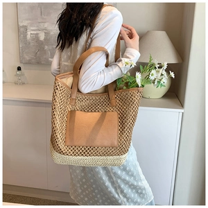 Detail of two-tone woven straw tote bag with leather pocket and shoulder straps