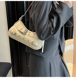 Vue détaillée du sac baguette blanc crème avec boucles argentées et œillets métalliques