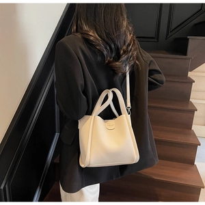 Détail du sac seau blanc crème avec texture cuir grainé et bandoulière amovible