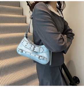 Détail du sac baguette bleu clair style moto vintage avec boucles argentées et œillets