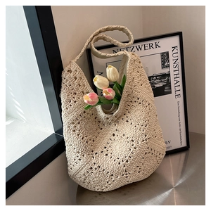 Detail of handmade crochet tote bag with intricate floral cut-out patterns and wide strap