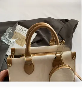 Détail d'un sac cabas bicolore chic avec un petit porte-monnaie rond et finitions dorées