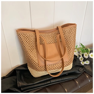 Close-up of woven straw tote bag featuring contrast faux leather pocket and fine stitching