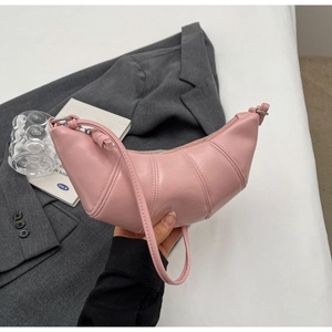Detailed close-up of pink crescent croissant bag with pleated glossy synthetic leather