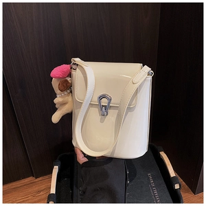 Détail du sac seau blanc crème avec fermoir argenté et breloque chiot adorable