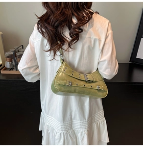 Détail du sac baguette vert clair style Y2K avec boucles argentées sur chemise