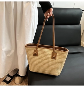 Vue détaillée du sac cabas en paille tissée avec lanières en cuir brun et nœuds