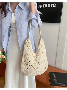 Handmade cream crochet tote bag with hollow flower pattern worn by a model