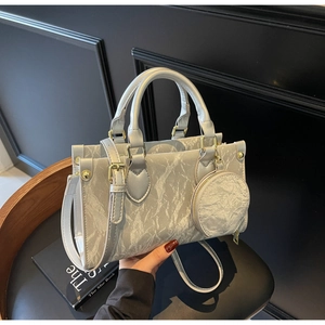 Détail du sac argenté à texture marbrée avec son porte-monnaie rond assorti en accessoire