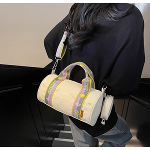 Détail du sac cylindrique beige avec bandoulière jacquard et mini pochette amovible