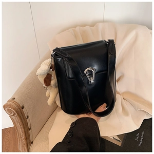 Détail du sac seau noir avec fermoir fer à cheval argenté et breloque chien en peluche