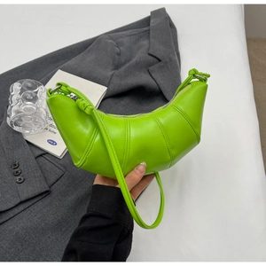 Detail of a bright green croissant bag with quilted pleats and metallic zipper closure