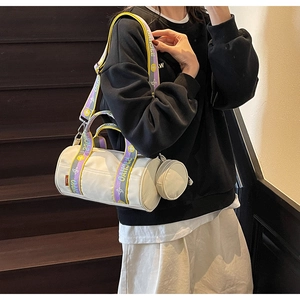Détail du sac cylindrique en toile blanche avec sa bandoulière tissée colorée SVCHAO