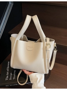 Sac seau minimaliste en cuir beige avec double poignée et détails dorés pour femme