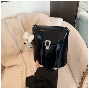 Détail du sac seau noir avec fermoir en métal argenté et breloque petit chien en peluche